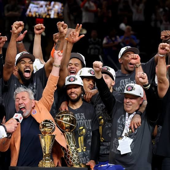 Knicks players and owner celebrating the 2026 NBA championship with the trophies